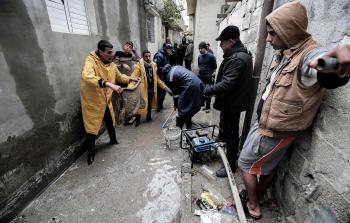 الدفاع المدني الفلسطيني يضخ المياه من بركة للأمطار في رفح (أ ف ب)