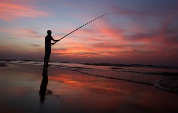 صياد على شاطئ بحر غزة  قبل المنخفض  الشتوي لحظة الغروب  (ياسر قديح)