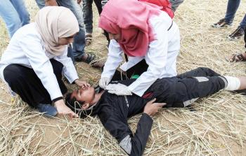 متطوعتان تسعفان مصاباً في خيام العودة (أ ف ب)