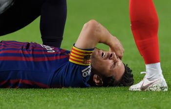ميسي ملقى على الأرض إثر إصابته أمس (أ ف ب)