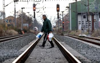 مواطن يوناني يمشي على السكة الحديدية المتوقفة عن العمل بسبب الإضراب العام - (أ ف ب)