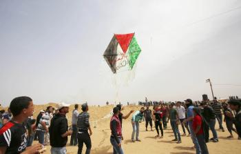 شبان يطلقون طائرة ورقية خلال مشاركتهم في مسيرة العودة شرق خانيونس (تصوير / رمضان الأغا)