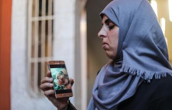 والدته تنظر إلى صورته عبر الهاتف المحمول (الأناضول)