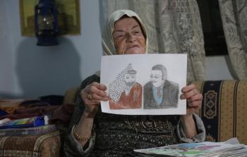 الفلسطينية لحلوح تستعرض إحدى لوحاتها (الأناضول)