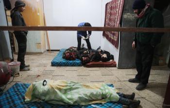 مسعفون يتفقدون جثث ضحايا مدنيين في أحد مستشفيات دوما أمس (أ ف ب)