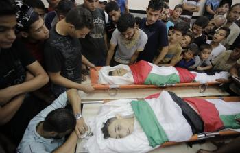 مواطنون يلقون نظرة الوداع على الشهيديْن في غزة أمس (تصوير / رمضان الأغا)