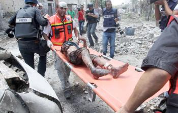 صحفيون ينقلون أحد المصابين في الحرب الأخيرة على غزة (أرشيف)