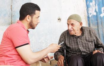 الزميل يحيى اليعقوبي (يميناً) أثناء لقائه بالحاج أيوب كلاب (يساراً) - تصوير / ياسر فتحي