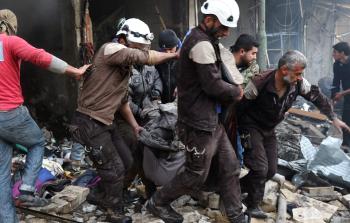 رجال دفاع مدني سوريون ينتشلون الجثث إثر قصف روسي لمبنى في معرة النعمان (أ ف )