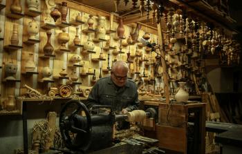 هشام كحيل وهو يصنع تحفه الخشبية (الأناضول)