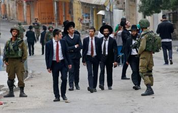 مستوطنون يتجولون في شوارع الخليل (أ ف ب)