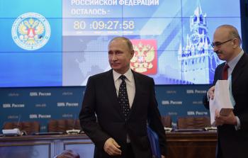 بوتين (يساراً) أثناء تقديمه لأوراق ترشحه (أ ف ب)