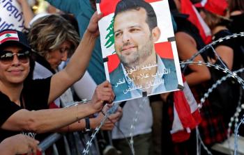 متظاهرون يحملون صورة الناشط علاء أبو فخر