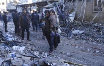 مواطن سوري يحمل طفليه في سورية (أرشيف)بعد سلسلة من القصف السوري الروسي لأدلب