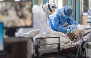 أطباء إلى جوار مريض مصاب بفيروس كورونا (أرشيف)