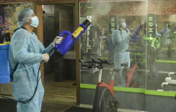 متطوع يرش واجهات محلات بمواد معقمة في غزة (أرشيف)