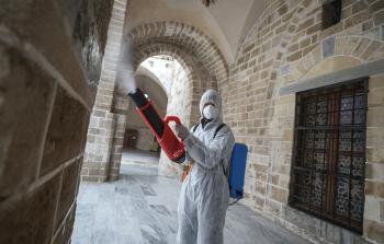 متطوعون يعقمون مسجداً بغزة (الأناضول)