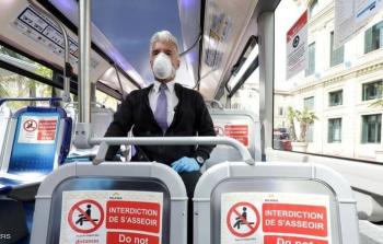 رجل يضع كمامة للوقاية من فيروس كورونا في حافلة بفرنسا (رويترز)