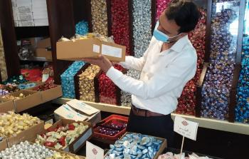 أحد طواقم وزارة الاقتصاد يجري فحصا على منتجات مستلزمات العيد في المحال التجارية