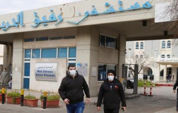 مواطنان لبنانيان يرتديان أقنعة واقية أمام مستشفى 