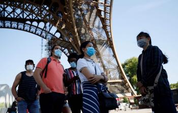 زوار إلى جوار برج إيفل بالعاصمة الفرنسية باريس (الفرنسية)