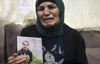 والدة الشهيد إياد الحلاق تحمل صورة نجلها