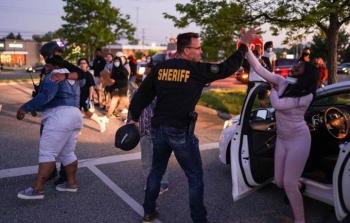 الشرطي الأمريكي كريس سوانسون يصافح المحتجين