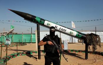 مقاتل من كتائب القسام يقف إلى جوار صاروخ R 160 محلي الصنع (أرشيف)
