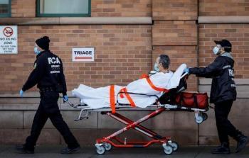 مسعفان يسيران بمصاب بفايروس كورونا في الولايات المتحدة الأمريكية (أرشيف)