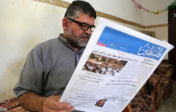 أبو جهاد يتصفح صحيفة فلسطين اليومية السياسية الشاملة (تصوير/ محمود الهندي)