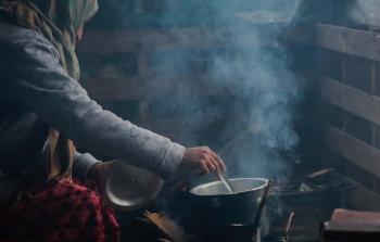 ربة منزل تطهو الطعام على النار في غزة (أرشيف)