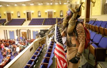 أحد المقتحمين يقف واسط مبنى الكونجرس الأمريكي