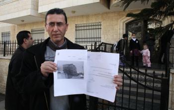 مواطن يحمل صورة من بلاغ الاخطار الإسرائيلي لهدم منزله (أرشيف)