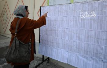 مواطنة تبحت في سجلات النشر والاعتراض داخل أحد المراكز بغزة (تصوير: محمود أبو حصيرة)