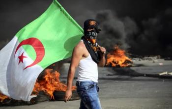 شاب فلسطيني يحمل علم الجزائر في المواجهات مع الاحتلال في الضفة الغربية (أرشيفية)