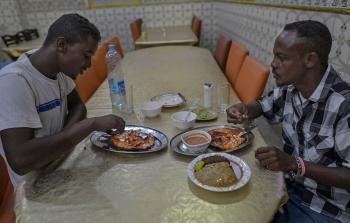 شخصان يتناولان السمك اليمني في جيبوتي 