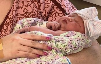 الطفلة جودا في حضن والدتها