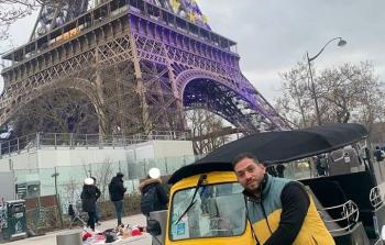 صورة الشاب مصري يظهر فيها واقفا أمام برج إيفل