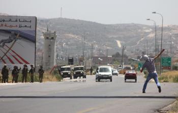 شاب يلقي الحجارة على جنود الاحتلال في حوارة