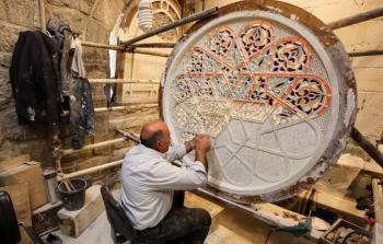 أحد الحرفيين يعكف على وضع اللمسات الجمالية على نافذة للمسجد الأقصى