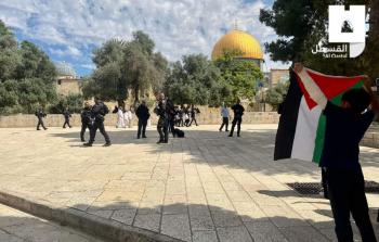 طفل مقدسي يرفع علم فلسطين خلال اقتحام المستوطنين لساحات المسجد الأقصى اليوم