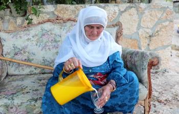 حاجة فلسطينية وفي يديها مشروب المقيقة