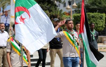 عنصر من عناصر الكشافة يؤدي التحية للعلم الجزائري والفلسطيني (تصوير: ياسر فتحي)