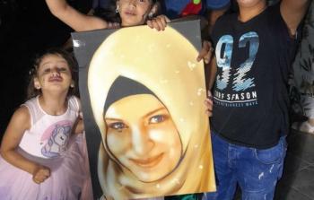 أطفال الأسيرة فدوى حمادة يرفعون صورة لوالدتهم
