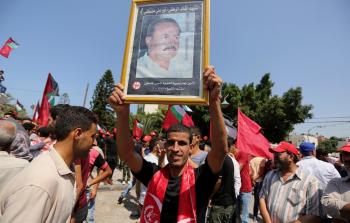 أحد أنصار الجبهة الشعبية يرفع صورة للقيادي الشهيد أبو علي مصطفى