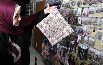 الخمسينية سحر حرز الله تحمل في يدها أحد أعمالها