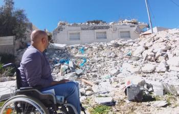 حاتم أبو ريالة أمام منزله المدمر