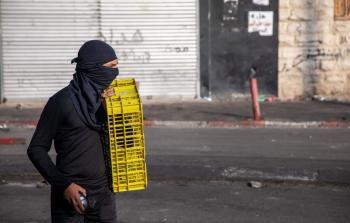 شاب فلسطيني يرشق الحجارة على قوات الاحتلال في شعفاط بالقدس المحتلة