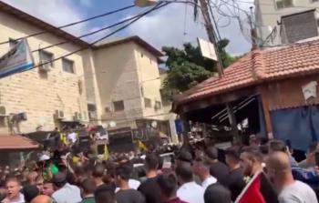 لحظة محاولة سحب أحد عناصر أمن السلطة لراية حماس من أحد الشبان المشاركين