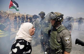 فلسطينية تدافع عن وجودها على أرضها أمام جندي (إسرائيلي)- أرشيف